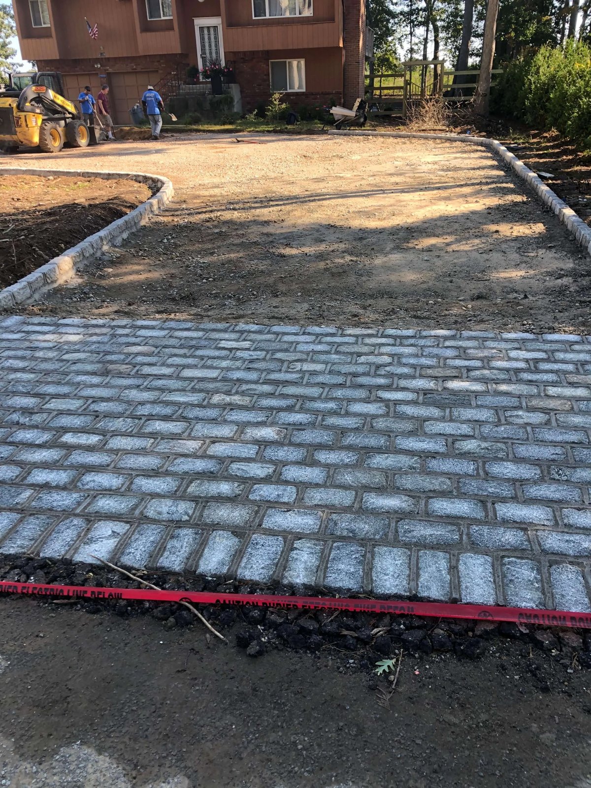 Cobblestone driveway apron with granite curb edging set ahead of the base preparation
